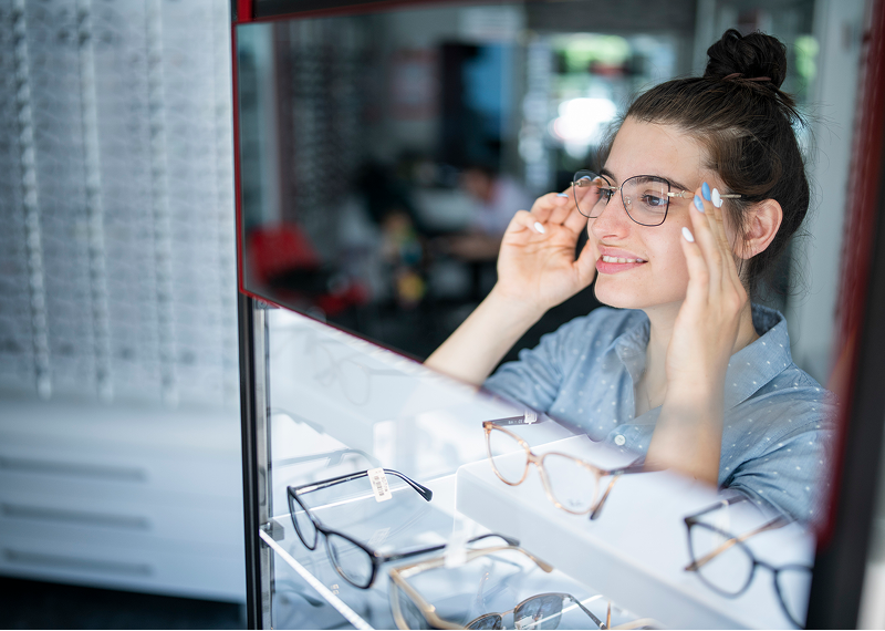 Woman trying on glasses at store