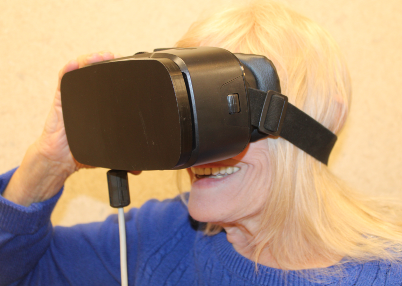 A person wearing a virtual reality headset, smiling.