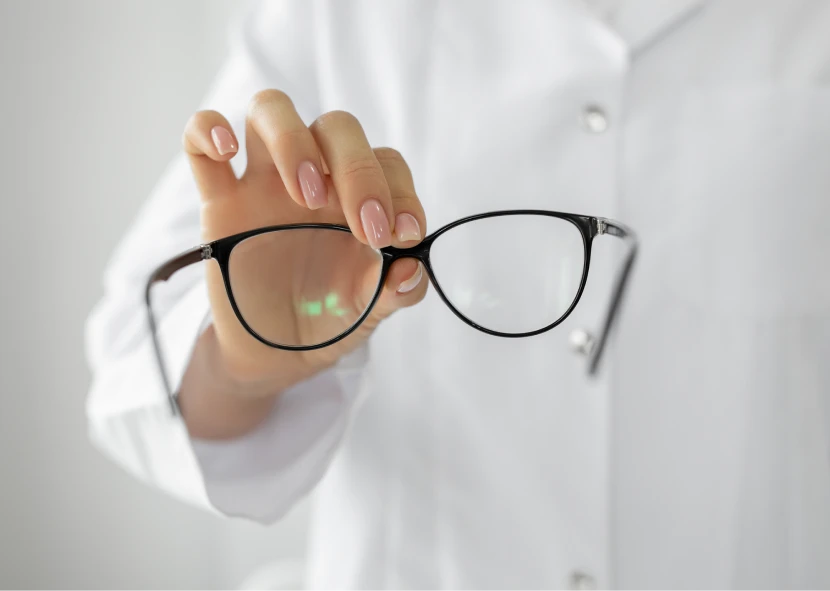 Person showing eyeglasses in hand